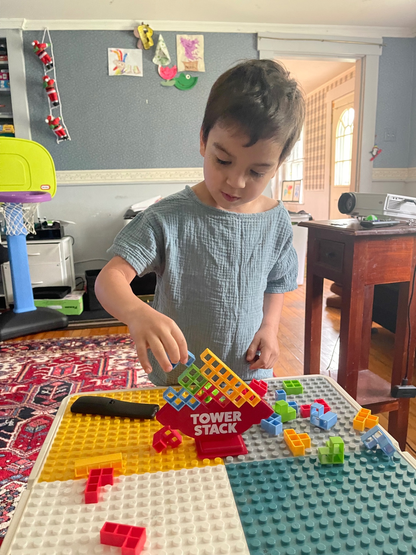 Noah carefully stacking colorful blocks on a Tower Stack balance game